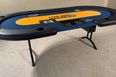 custom made poker table with dealer cut out, chip tray, shuffletech card shuffler and customer's commercial logo in the center of the table.
